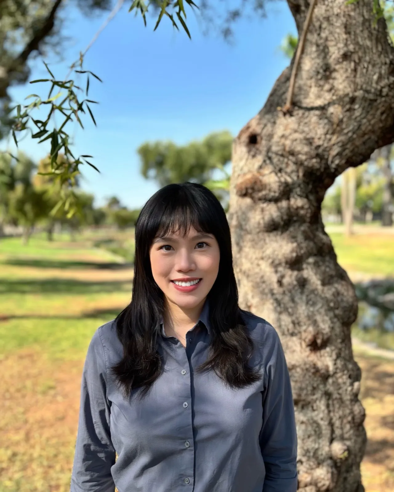 Angela Liu, smiling outdoors in a park
