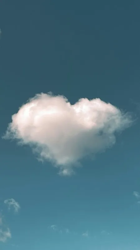 A heart-shaped cloud in a blue sky